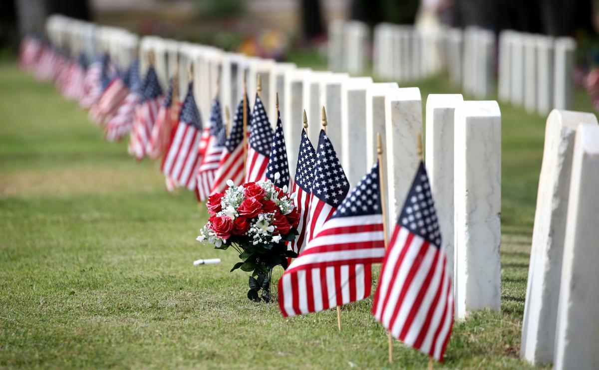 American flags in front of each gravestone in a cemetery
