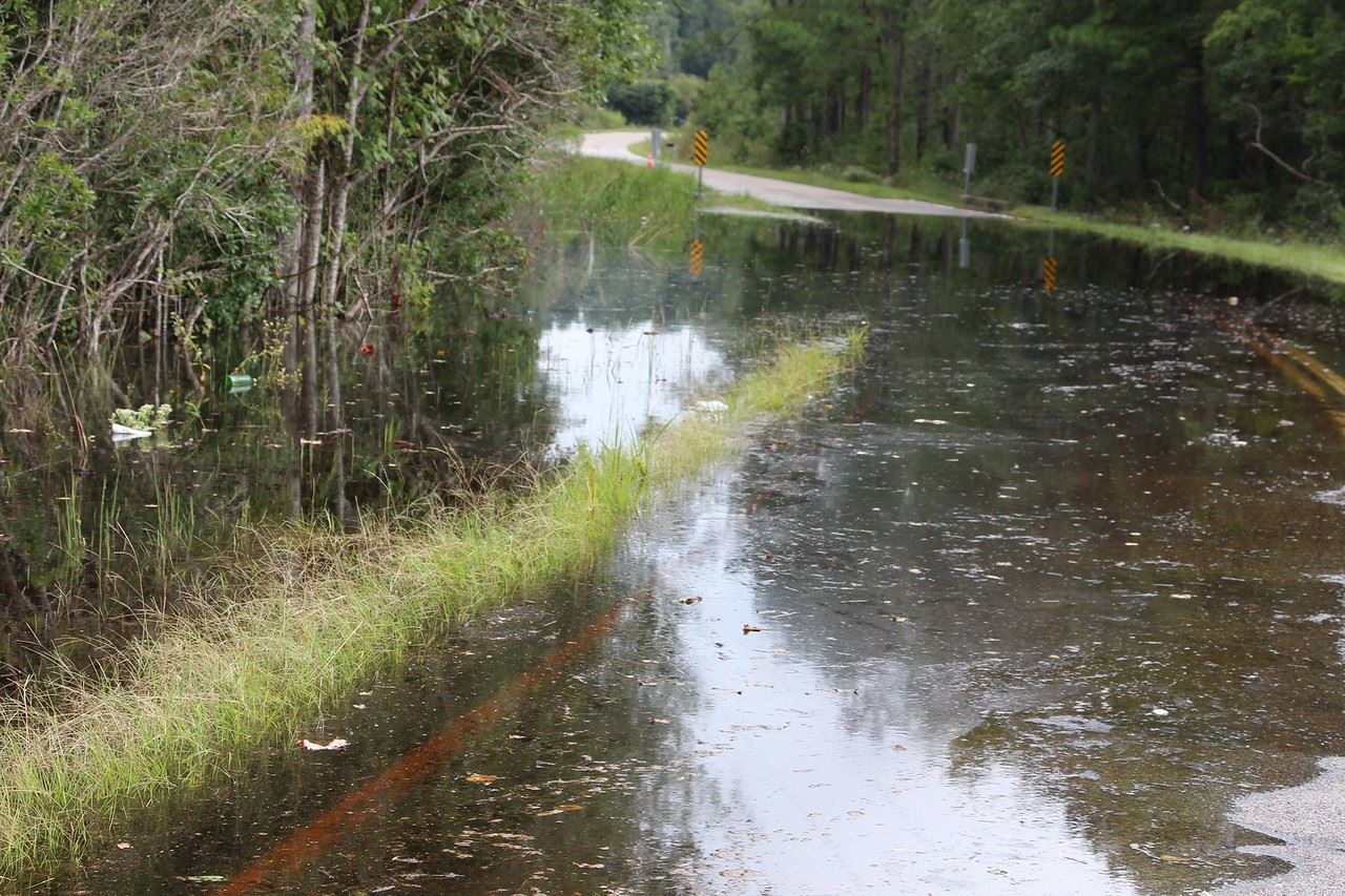 Floodwaters cover a two-lane road.