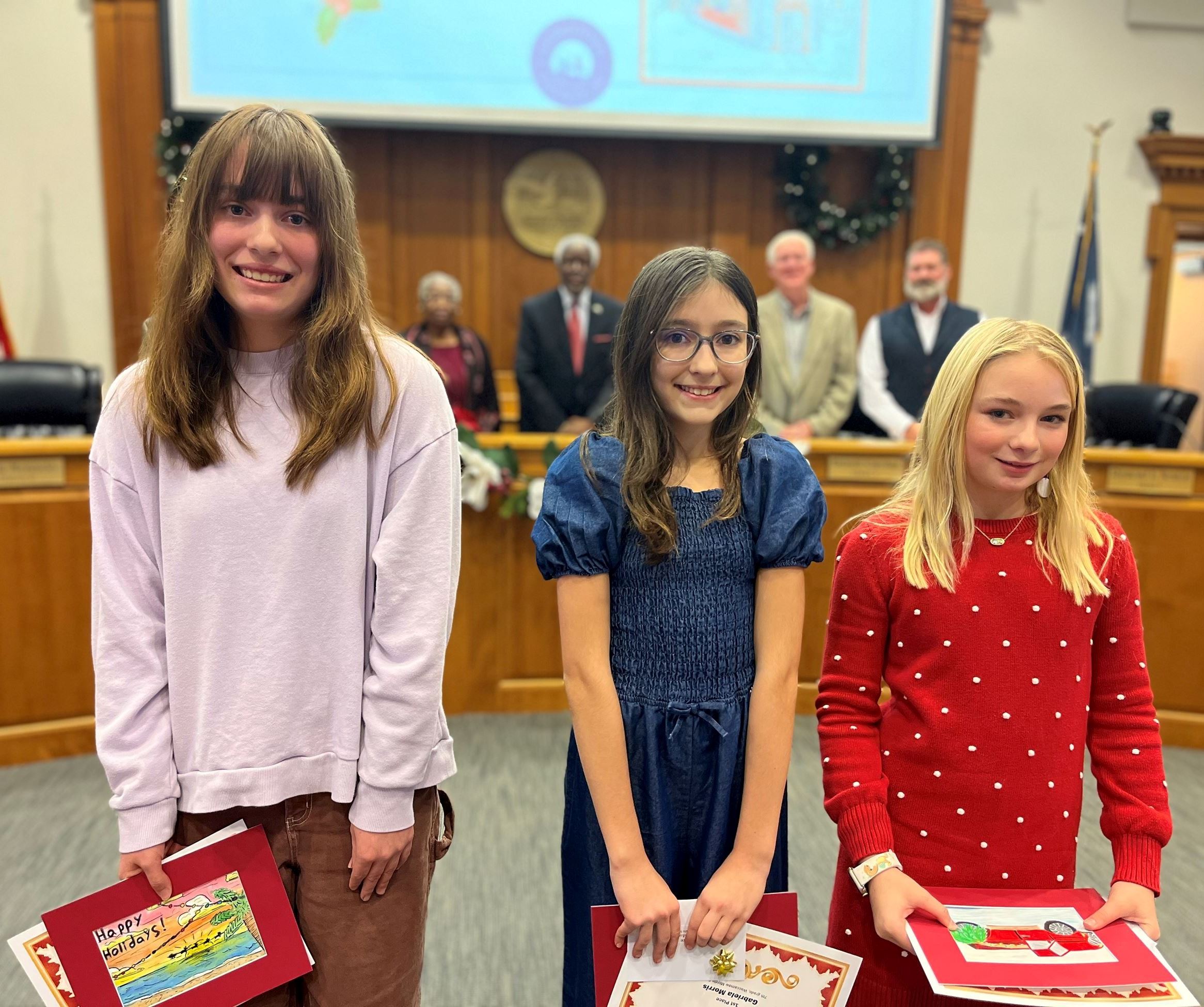 From left: Emmaline Lee, Gabriella Morris and MaryHope Magann stand in Council Chambers.