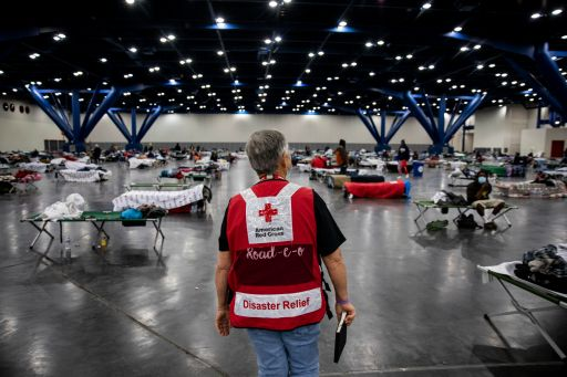 A Red Cross volunteer stands in the middle of a disaster shelter -- empty but ready for occupants