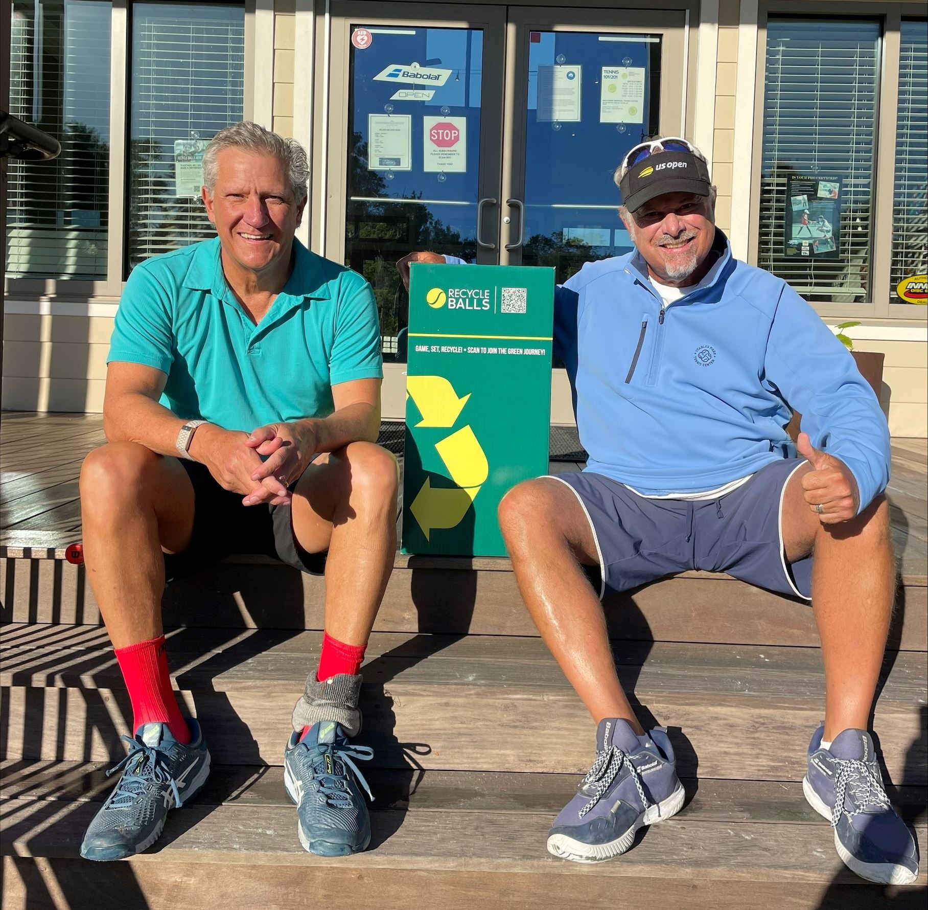 Mark Hawn and David Bromberg sit on the wooden porch steps at Waccamaw Regional Tennis Center