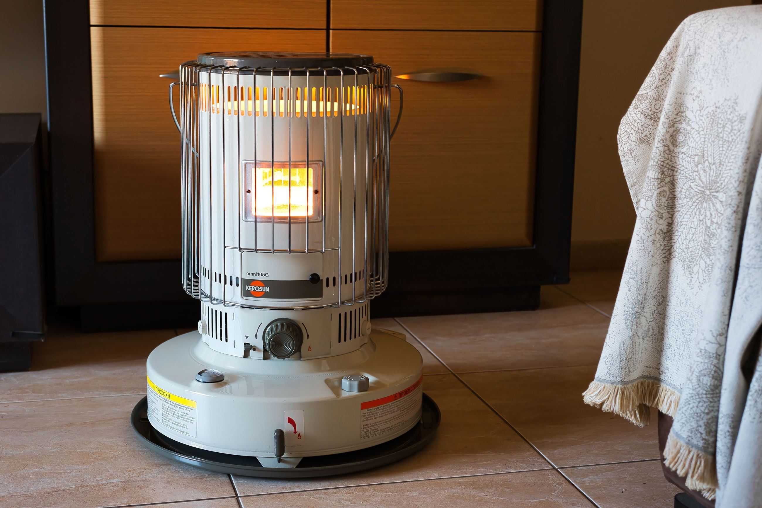 A lit kerosene heater sits in a room near bedding creating a fire risk