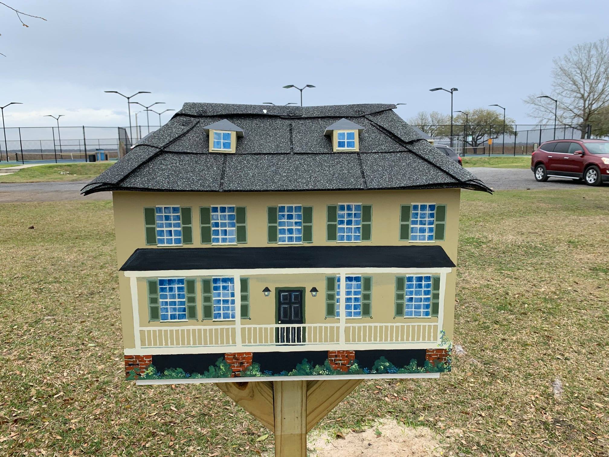 Little Library box painted to look like a house, standing at East Bay Park.